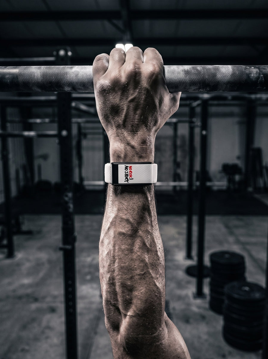 Athlete gripping a pull-up bar wearing a Strapion WHOOP band